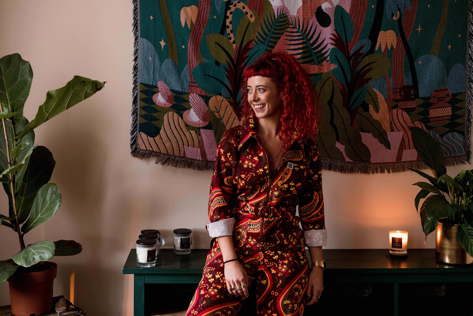 Emily Lamey in a patterned suit in front of a painted mural.