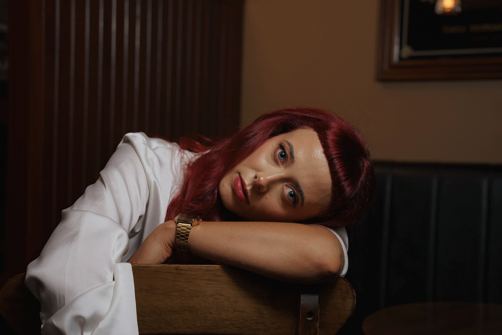 Emily Lamey resting on a table in a low-lit interior.