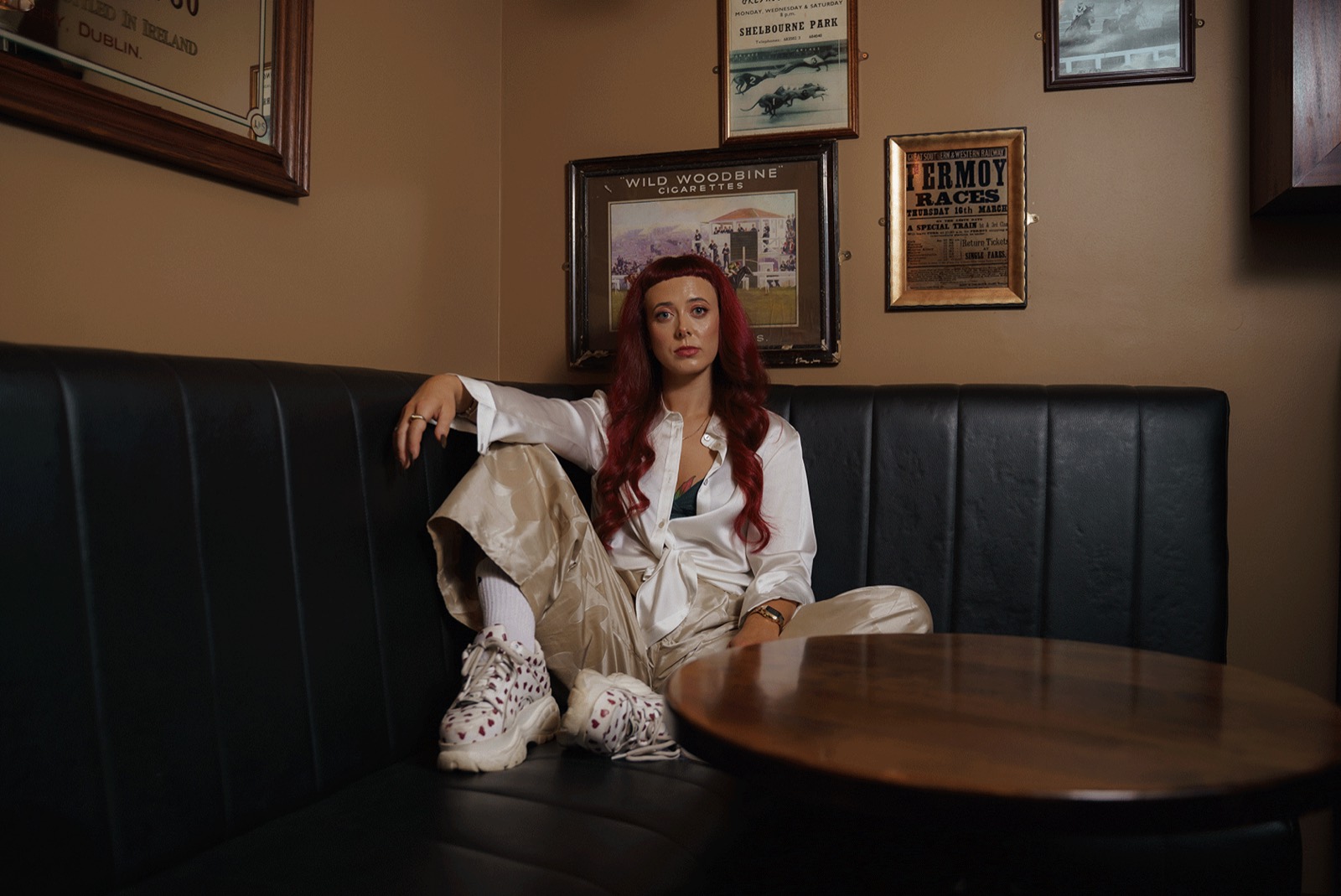 Emily Lamey seated in a booth wearing a cream suit.