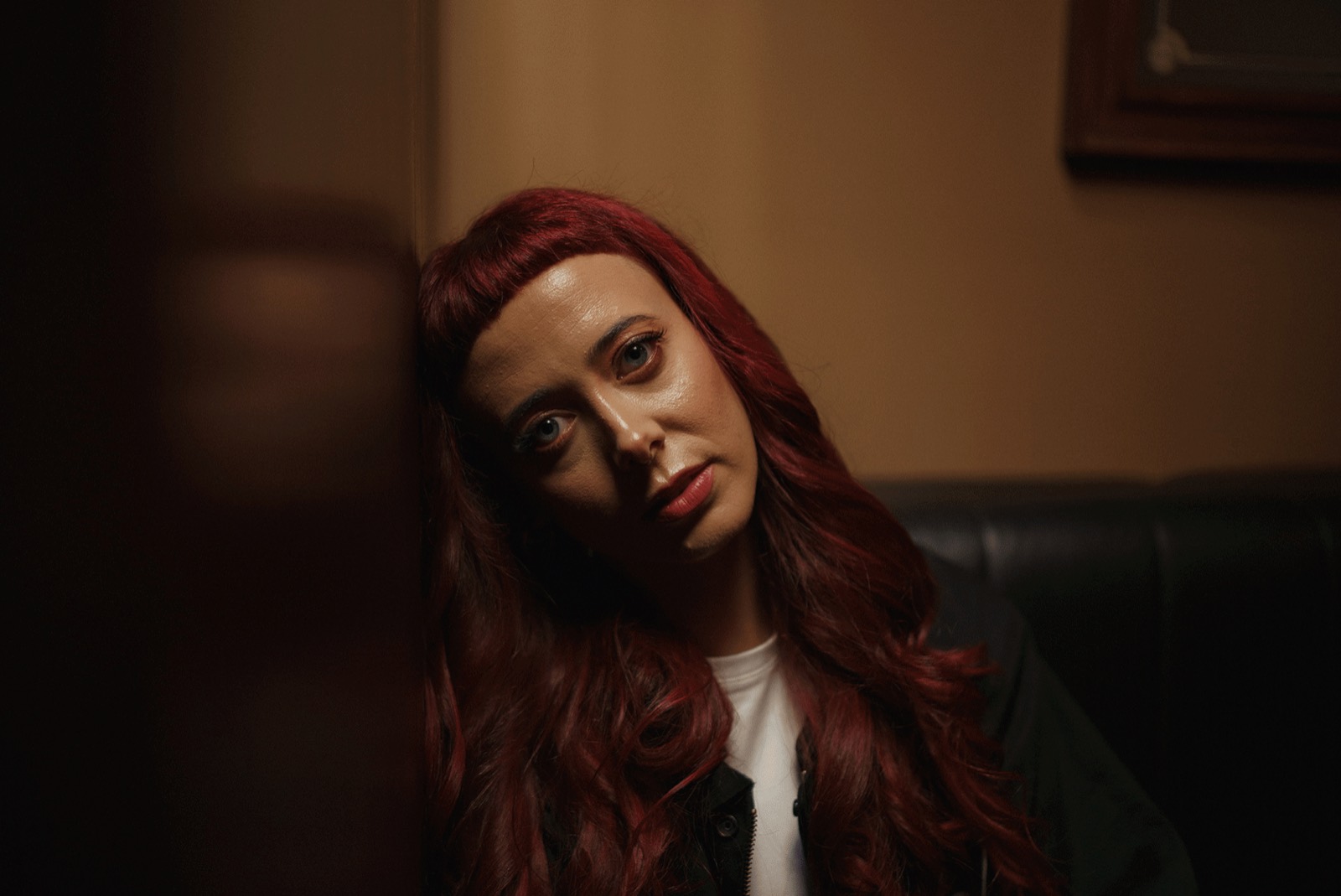 Emily Lamey photographed in a dark interior, looking to camera.